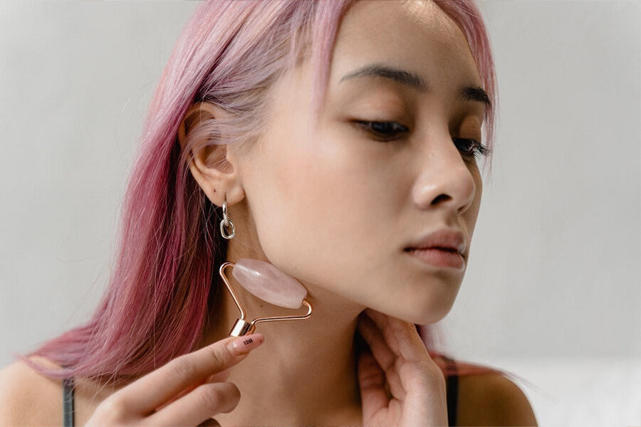 mujer usando rodillo facial