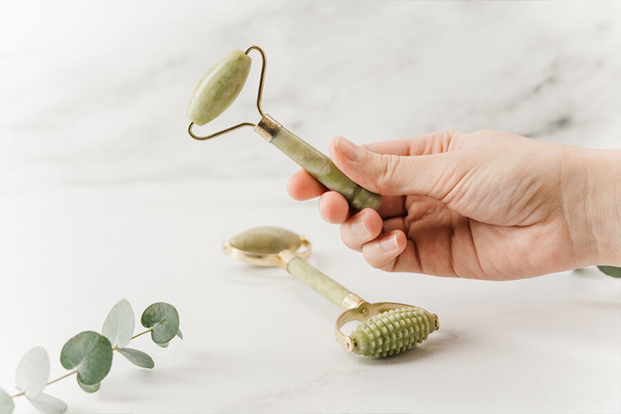 A jade roller being held in a hand
