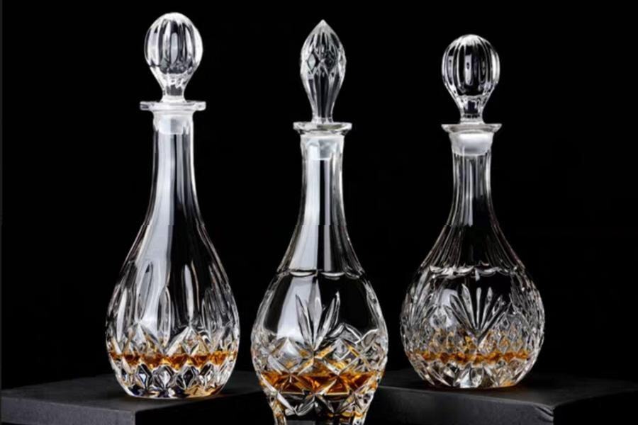 Three premium glass alcohol bottles with decorative lids