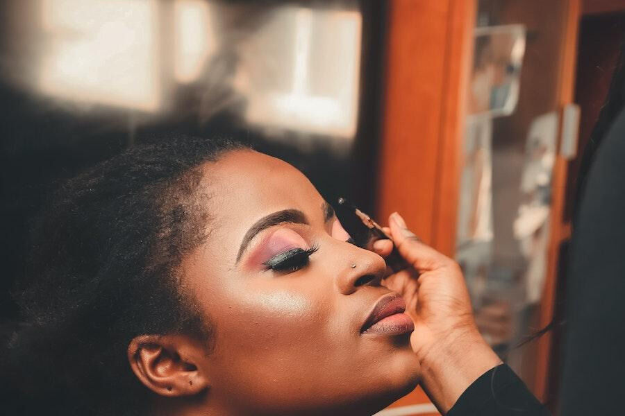 Lady applying colorful makeup on her face