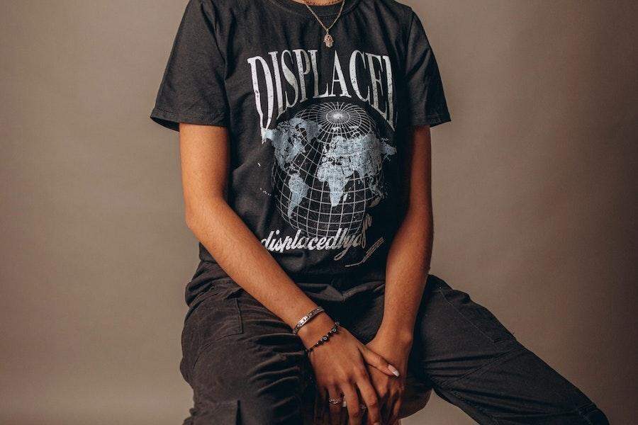 Женщина сидит на диване в черной футболке с рисунком