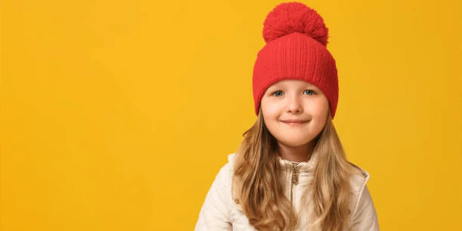 A cheerful child in a red beanie hat