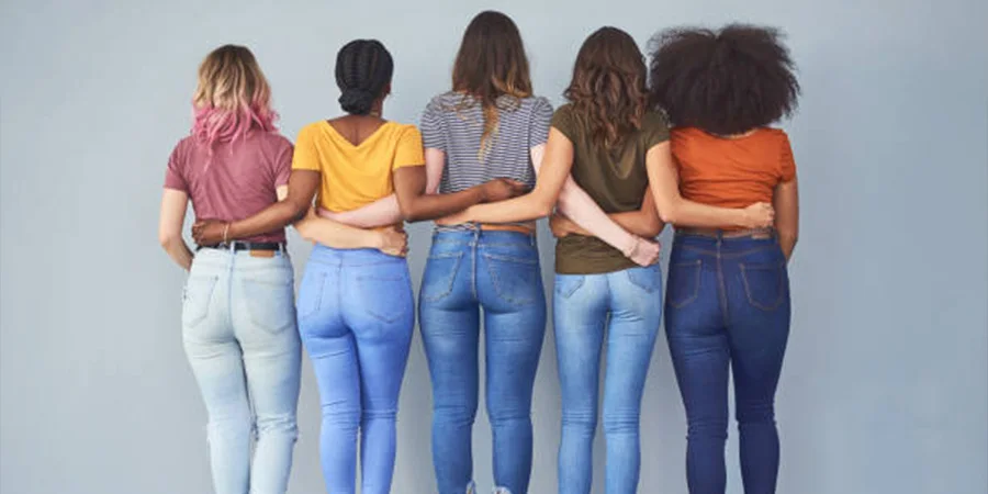 Five women lined up wearing different pairs of jeansFive women lined up wearing different pairs of jeans