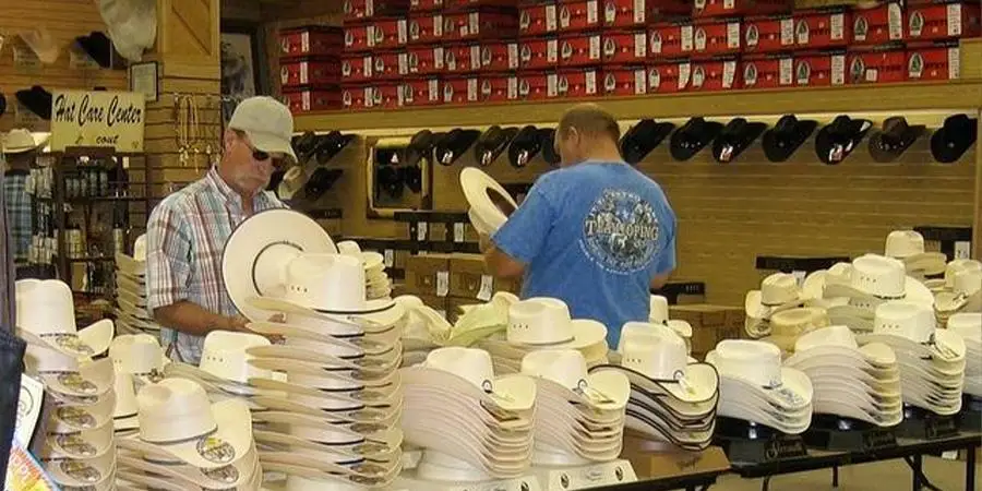 male customers sampling cowboy hats in a shop
