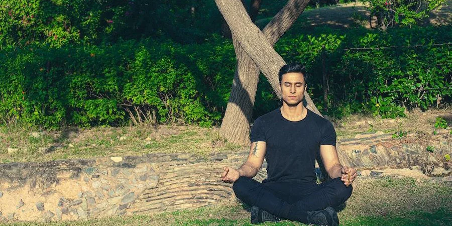 Man meditating in an all-black ensemble