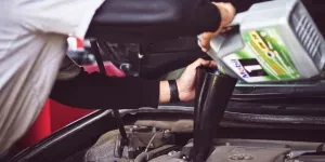 Mechanic pouring synthetic car oil into car