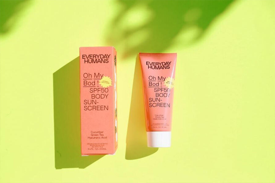SPF50 body sunscreen against a sunny yellow background