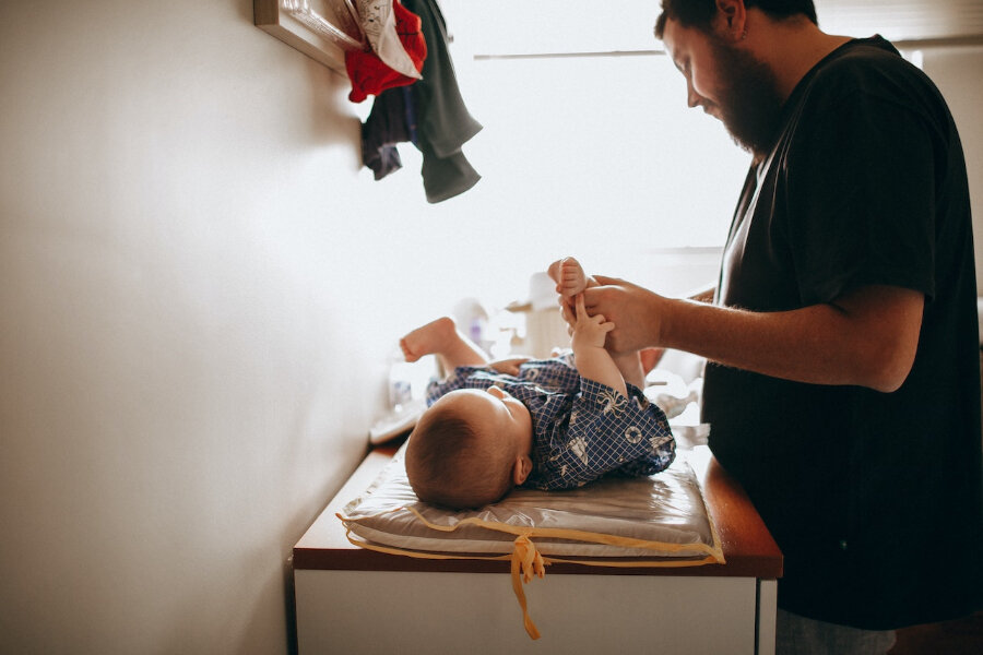Padre joven cambiando el pañal del bebé recién nacido