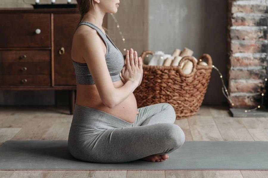 A pregnant woman doing yoga in leggings