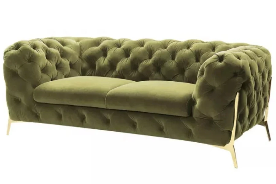 Um sofá Chesterfield de veludo verde de dois lugares