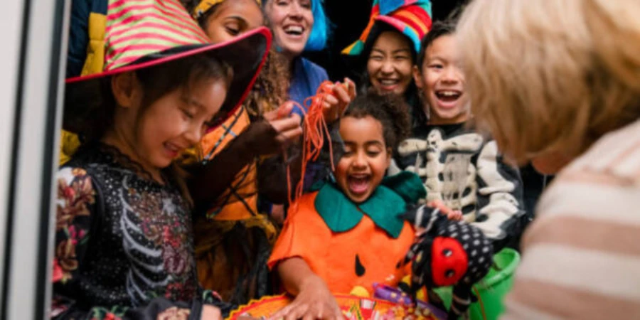 children at a door trick or treating with hats on
