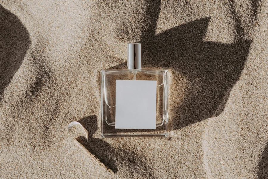 Gros plan d'un parfum dans le sable