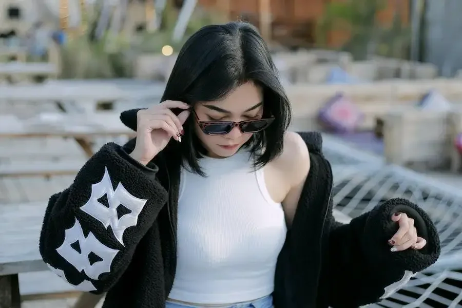 Lady rocking a white tank top and black jacket