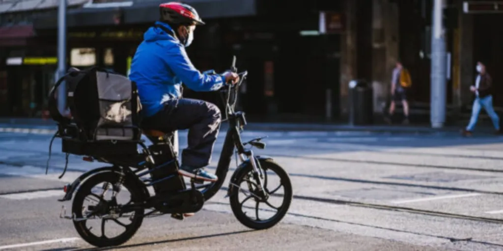 Man in blue jacket riding electric motorcycle on road