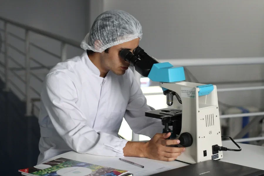 Man in laboratory looking through a microscope