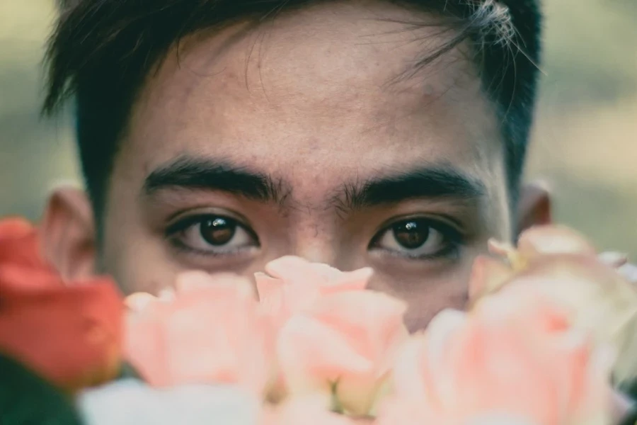 Homme regardant par-dessus un bouquet de fleurs