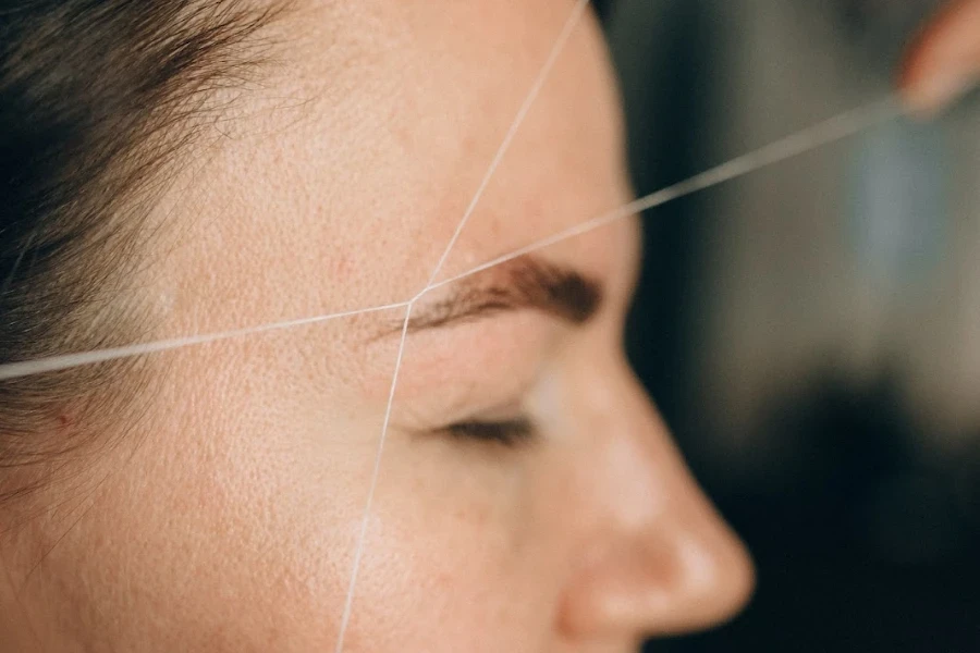 Person getting eyebrow threading procedure