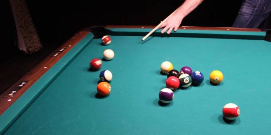 Person trying to hit ball in pocket on billiard table