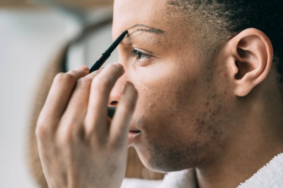 Person, die einen Augenbrauenstift verwendet, um eine Augenbraue nachzuzeichnen