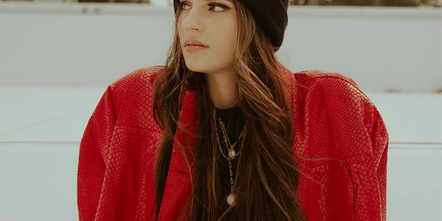 Woman wearing a red oversized jacket and beanie