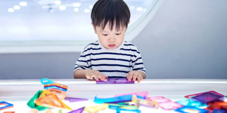Young child playing with colorful plastic transparent shapes