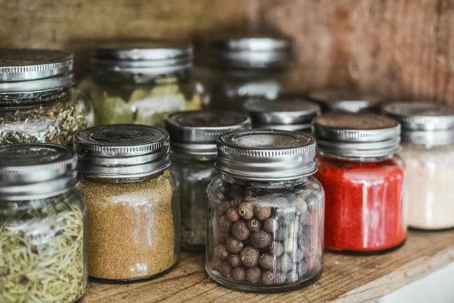 a bunch of glass bottles and jars on the cupboard