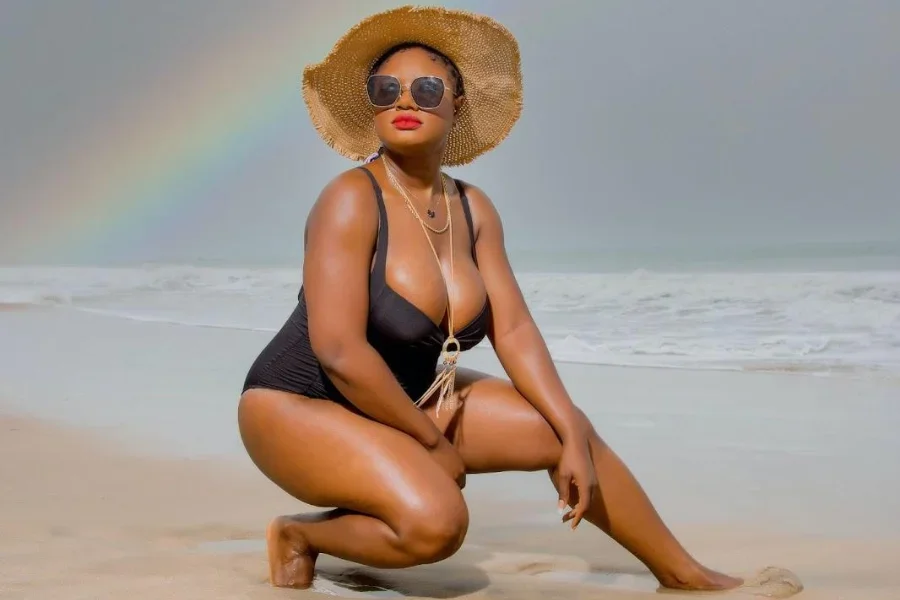 Lady rocking a black swimsuit and straw hat