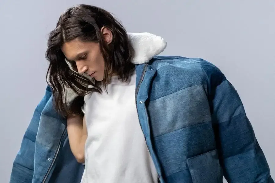 Man putting on a denim jacket with stylish detailing