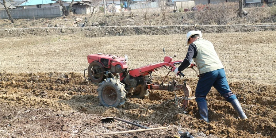 Man using a tiller to till soil