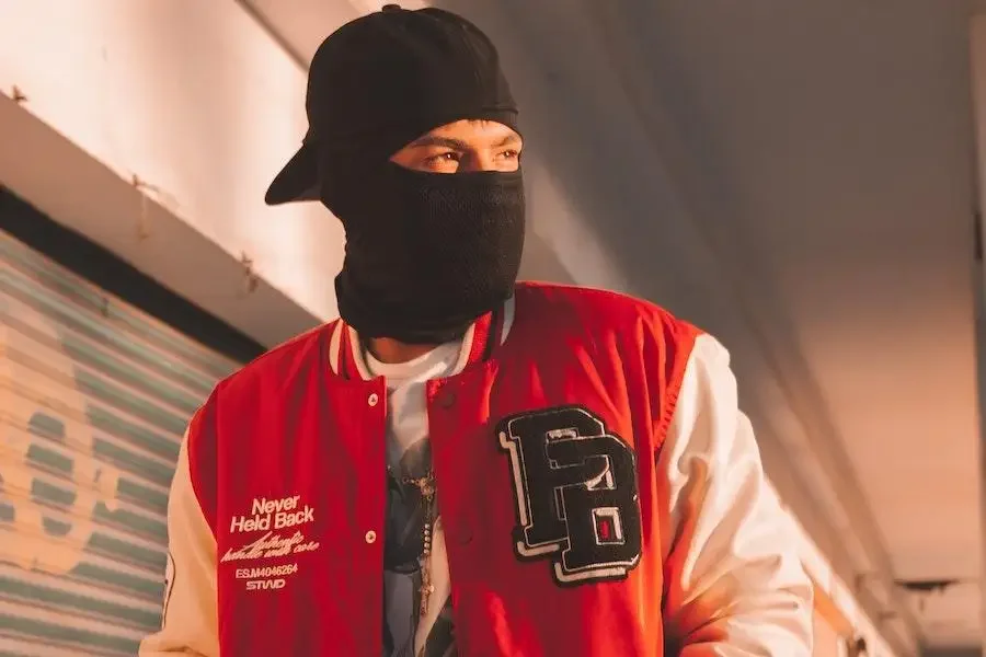 Man wearing a cap over a black balaclava