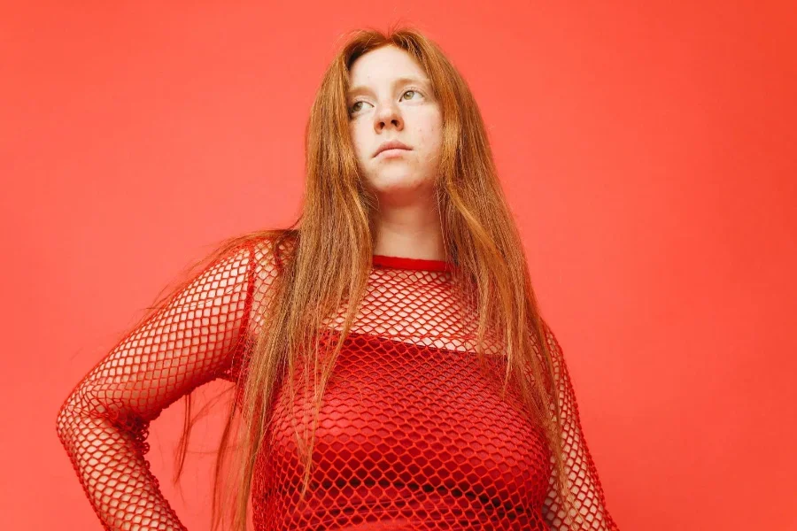 Wanita berambut merah dengan atasan jaring merah