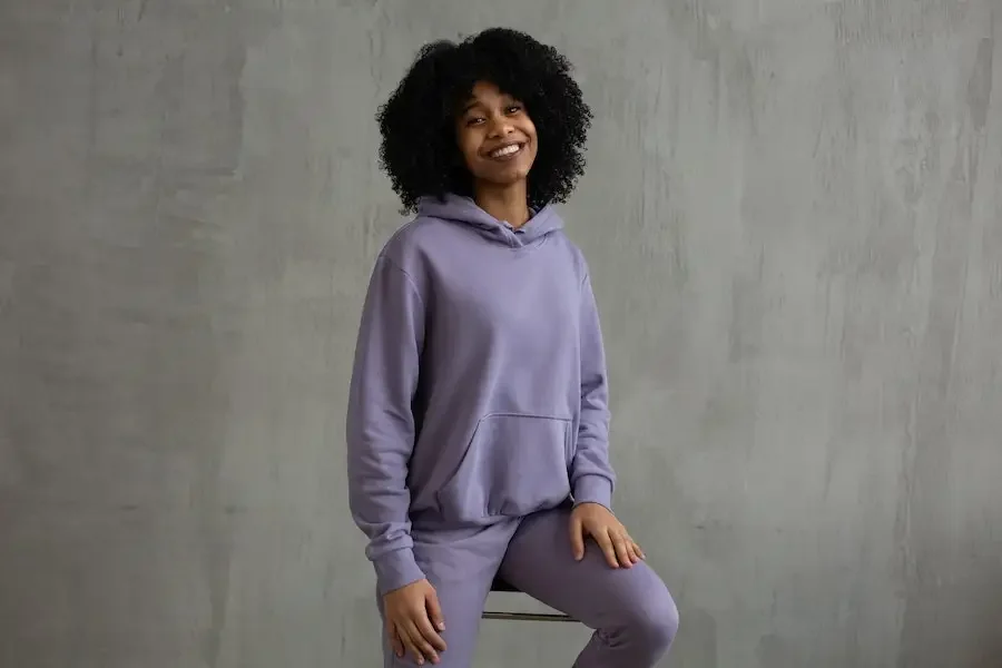 Smiling woman in a violet hoodie and sweatpant ensemble