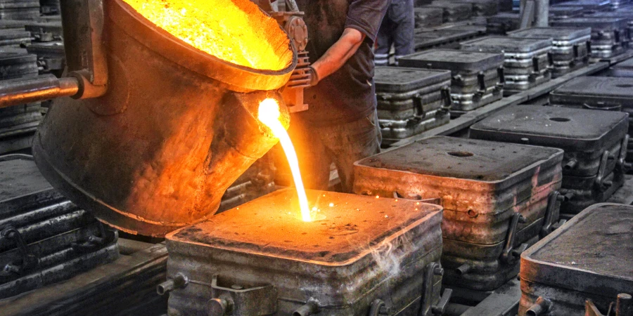 Worker casting metal in a factory