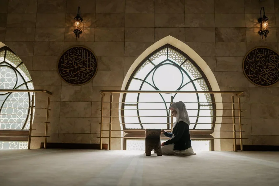 Young girl wearing hijab reading a book