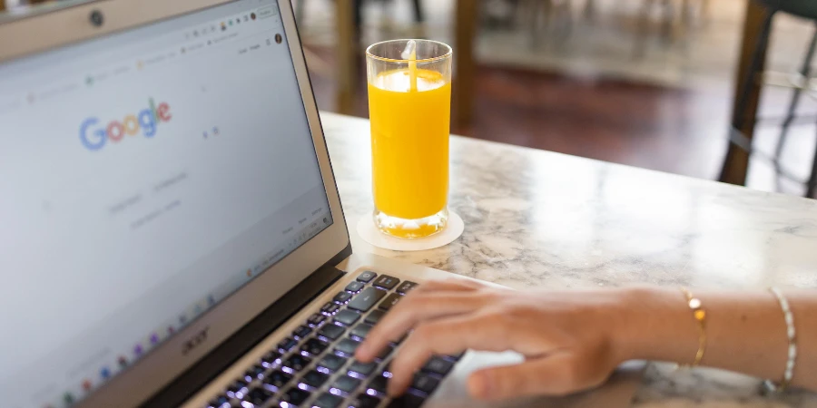 Woman using a computer laptop near a glass of juice