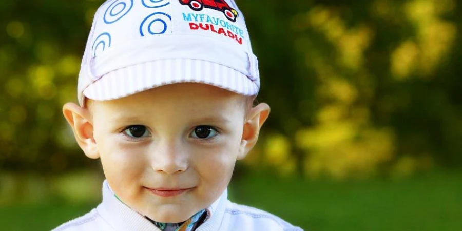 Young boy in white sports cap with custom logo