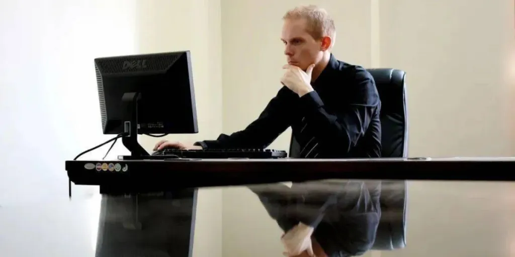 entrepreneur sitting on a desk, in front of a laptop