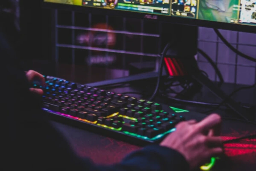 Mann benutzt Gaming-Tastatur und -Maus, um ein Spiel zu spielen