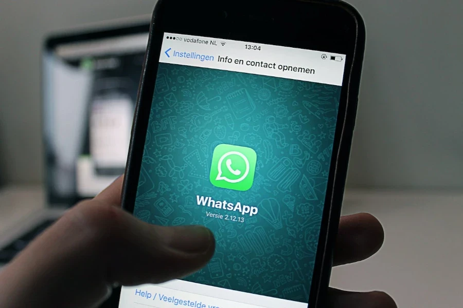 Persona che tiene il telefono che naviga verso il messenger Whatsapp