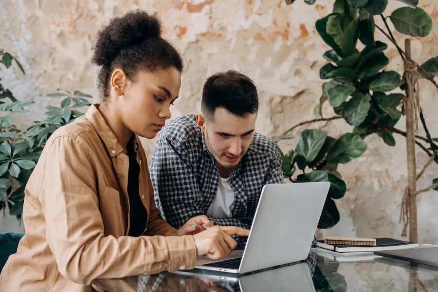 Two people doing research on a laptop