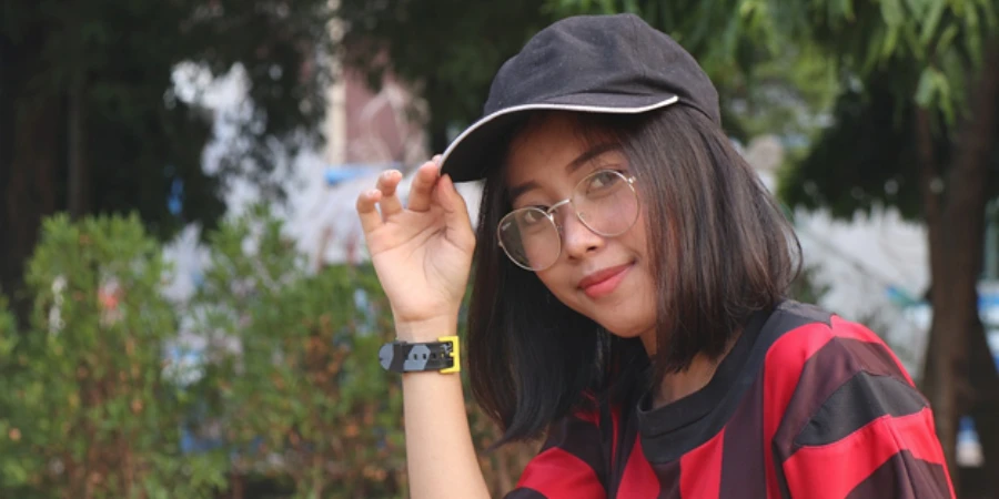 Girl with glasses wearing a black baseball cap with white trim