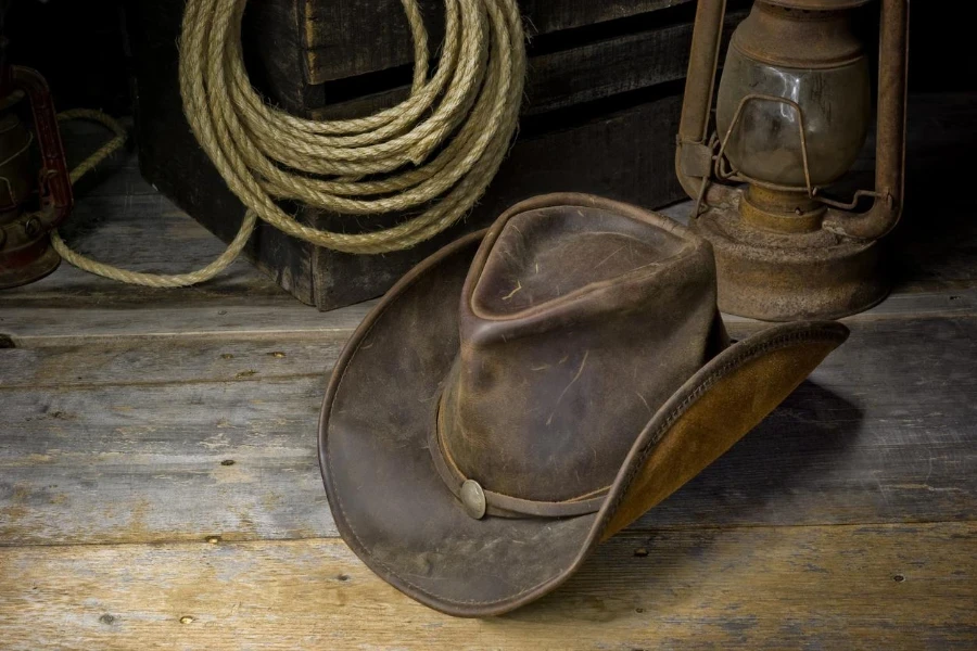 Viejo sombrero de vaquero delantero pellizco en un piso de madera