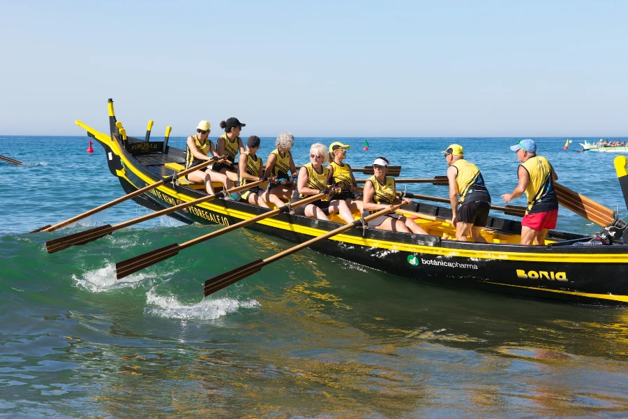 A group of people rowing a black boat