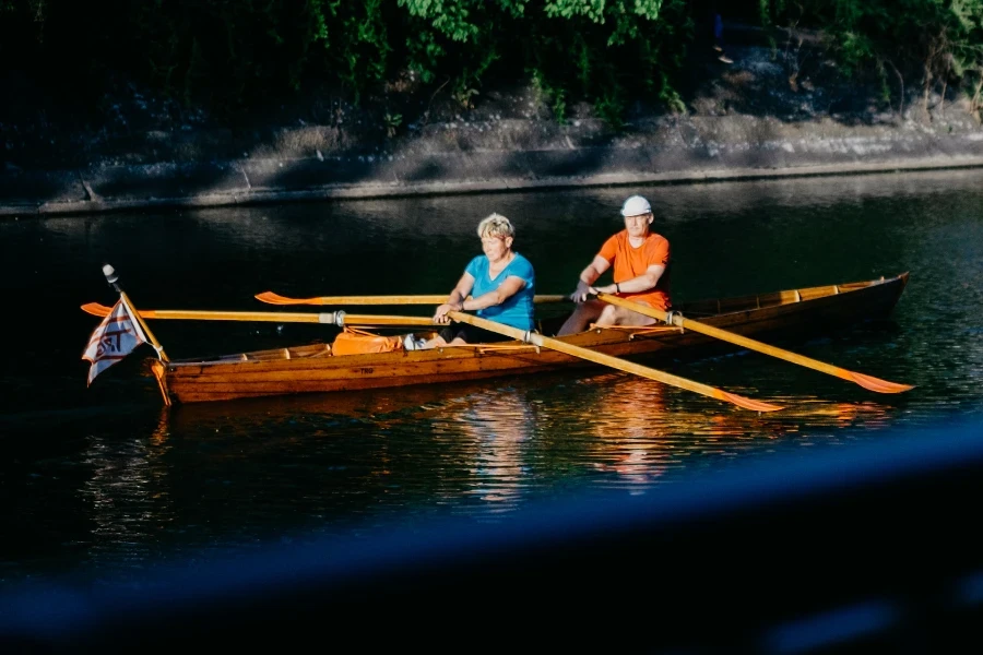 Seorang pria dan seorang wanita mendayung di perahu