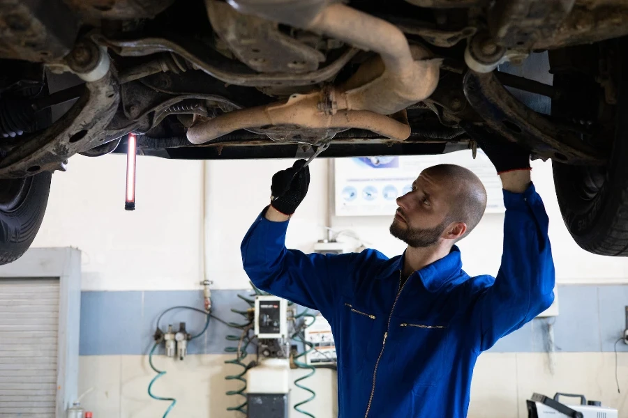 Um mecânico inspecionando o sistema de transmissão de um carro