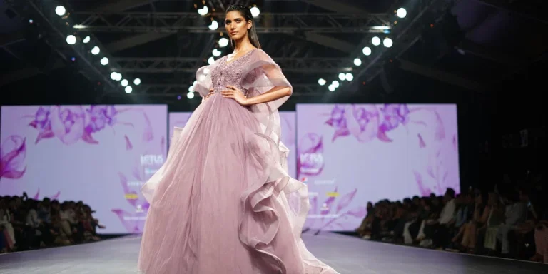 Una modella che indossa un abito rosa in passerella