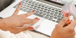 A woman inputting card details on the laptop