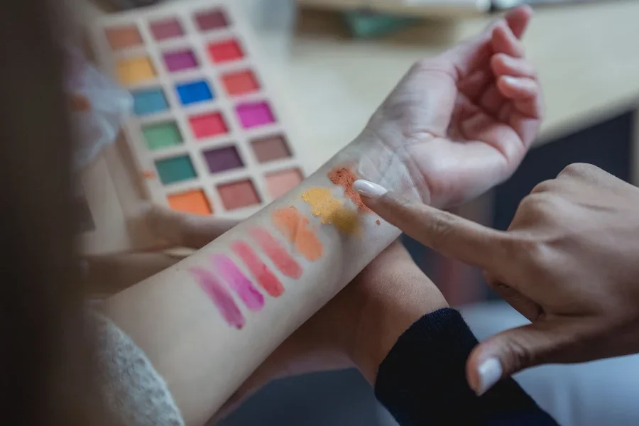 El brazo de una mujer mostrando los diferentes colores en una paleta poco profunda para los ojos