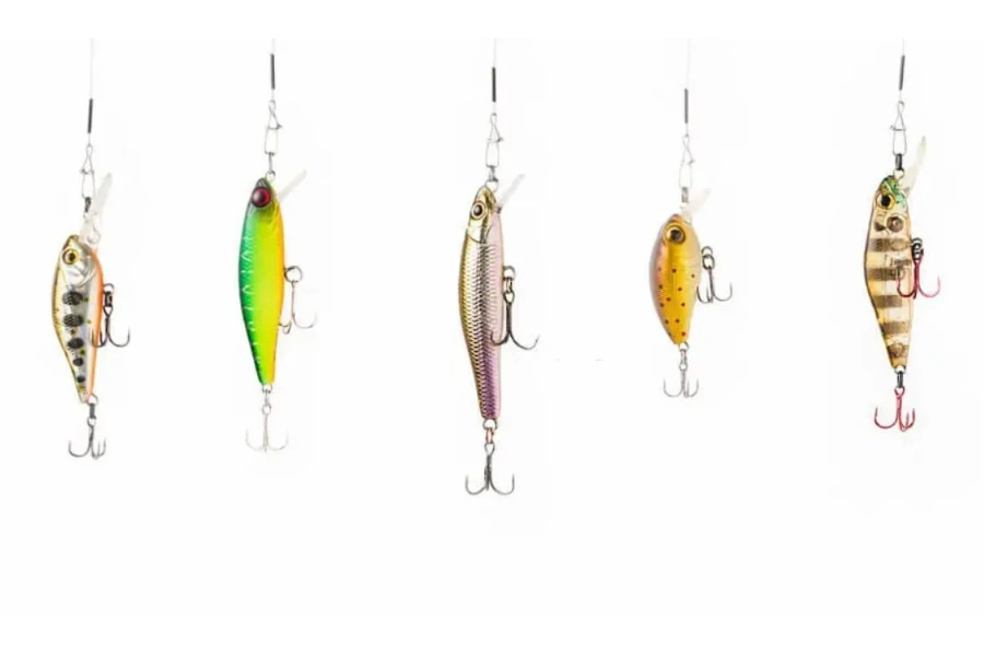Five types of fishing lures hanging from a fishing reel