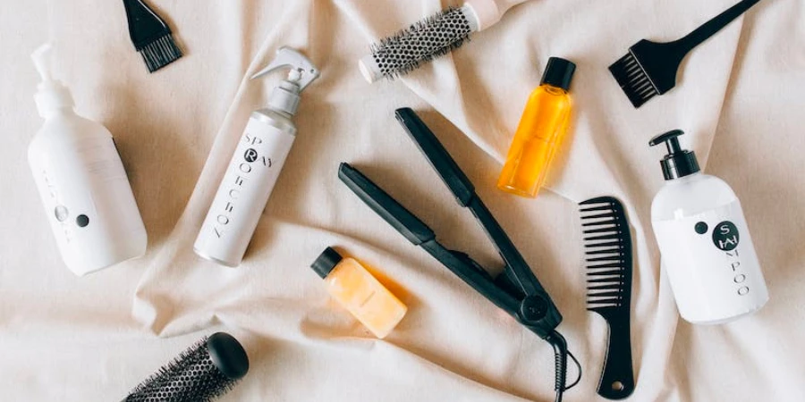 Hair care products and tools laid out on a piece of beige cloth
